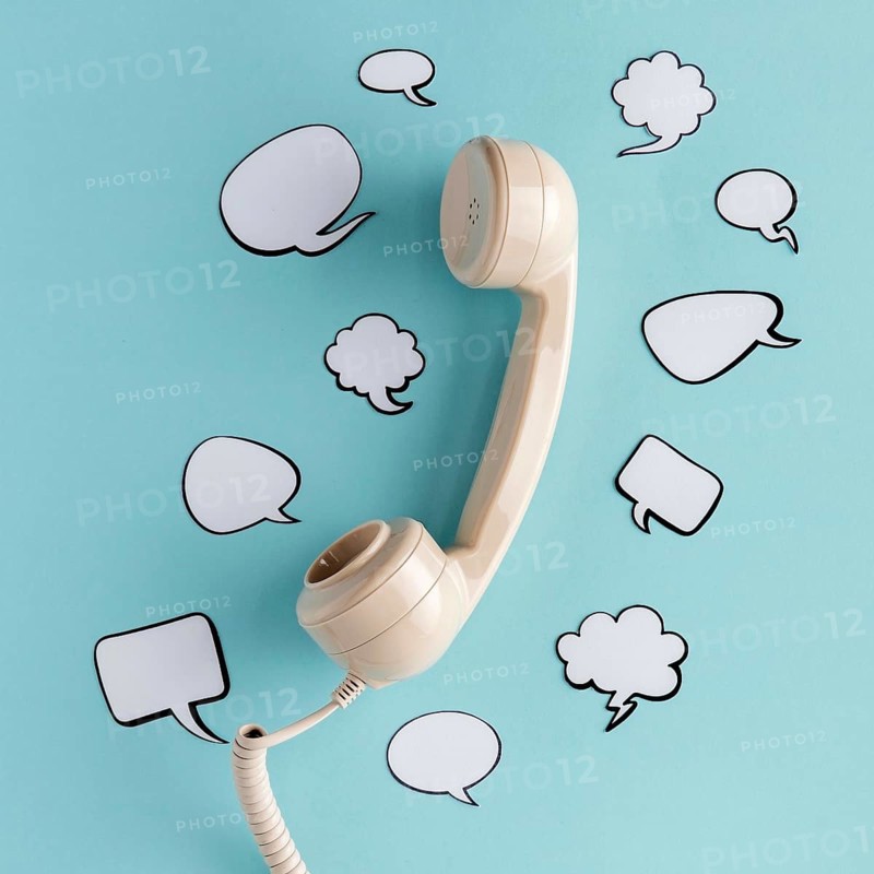 Flat lay chat bubbles with telephone receiver