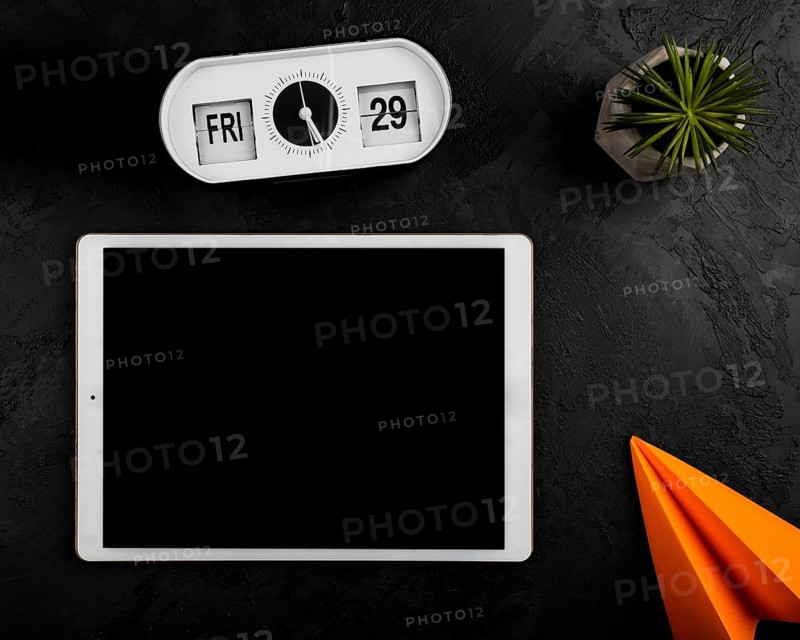 Flat lay tablet clock paper plane
