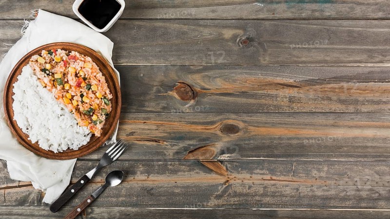Fried steamed rice wooden plate with fork spoon table