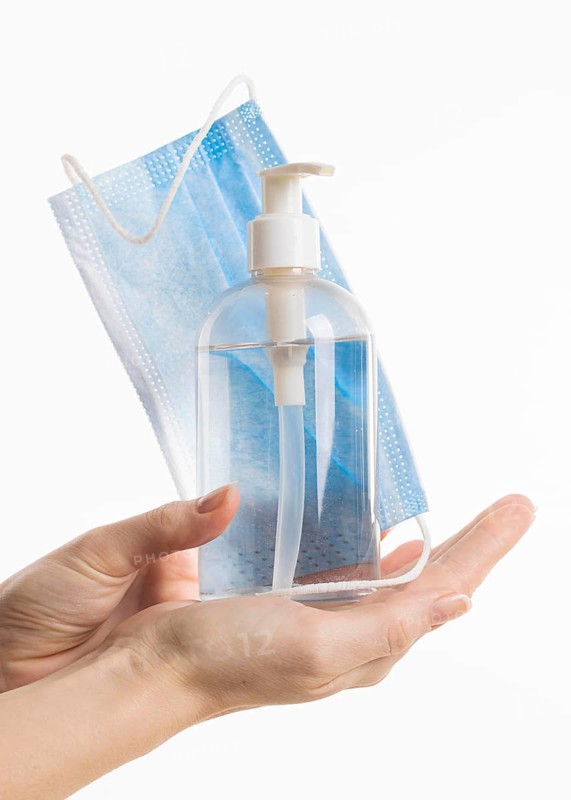 Front view hands holding hand sanitizer bottle medical mask