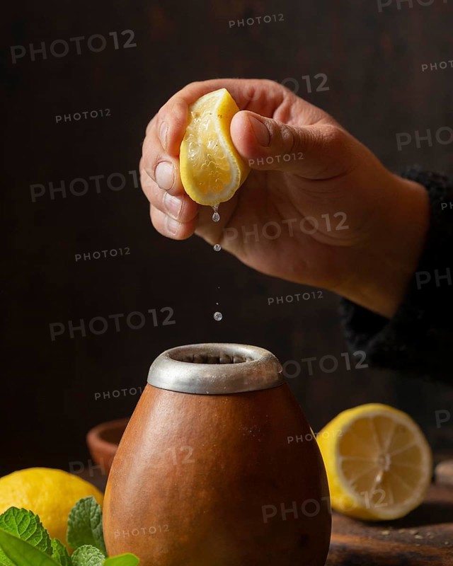 Front view hand squeezing lemon tea
