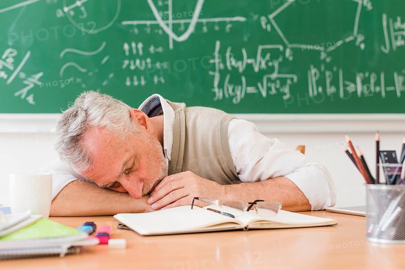 Grey haired teacher sleeping table