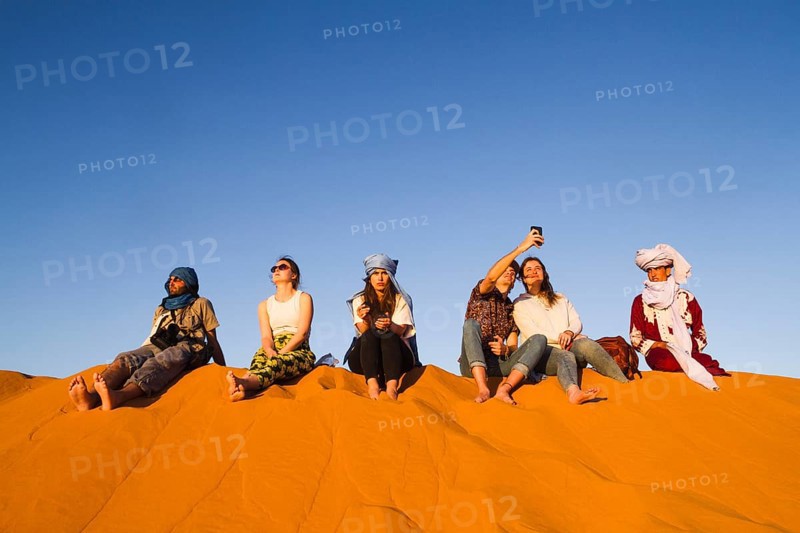 Group people sitting top dune