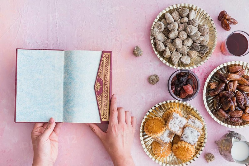Hands with koran table with sweets