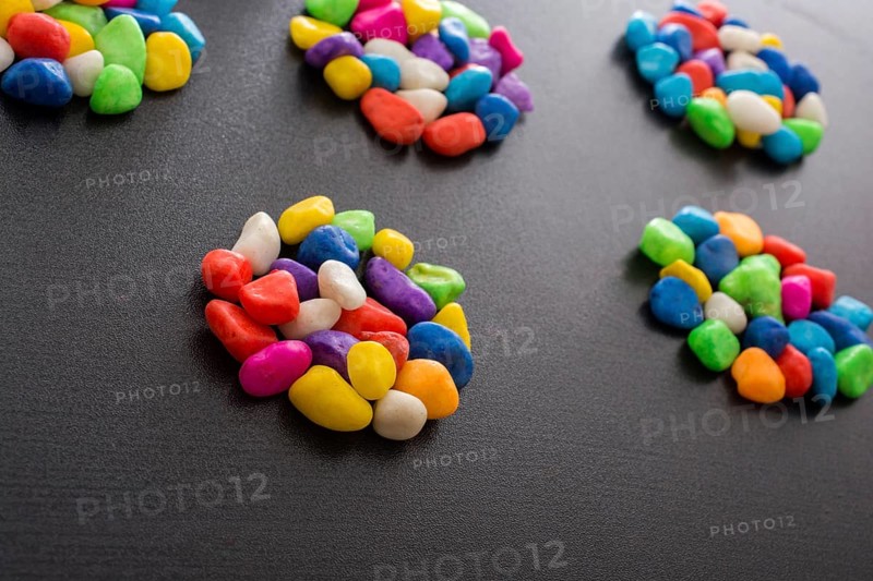 Pile of little colorful pebbles on black background