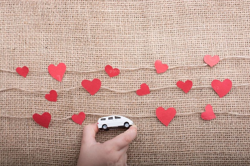 Love concept with car and paper heart on linen threads