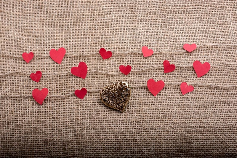 Love concept with heart shaped papers on linen threads