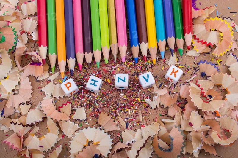 Color Pencils and letter cubes on the pencil shavings