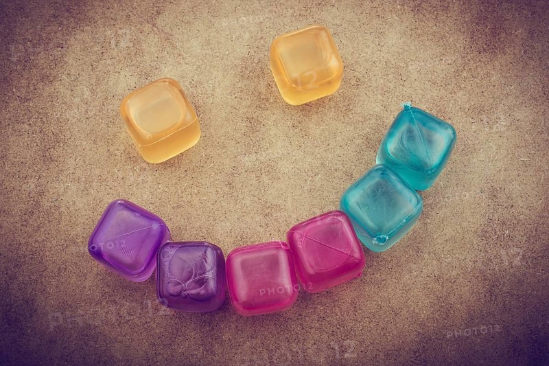 Fake colorful ice cubes on a brown background