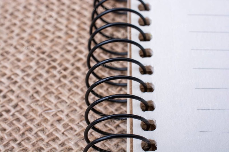 Brown color spiral notebook placed on a canvas background