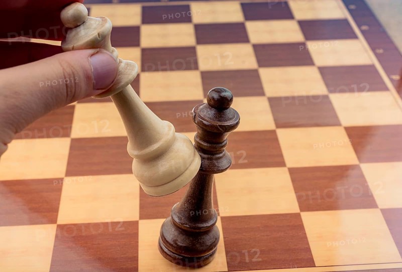 Person playing chess game making a move on board