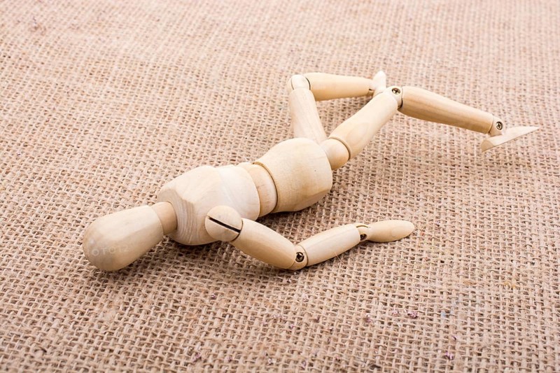 Wooden dolls of a man posing on canvas
