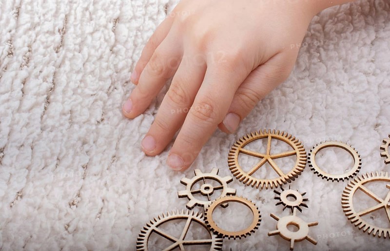 Hand holding gear wheels as the concept of mechanism