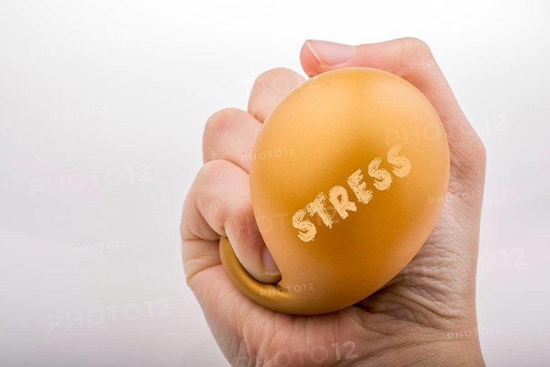 Squeezing yellow balloon with hand on a white background