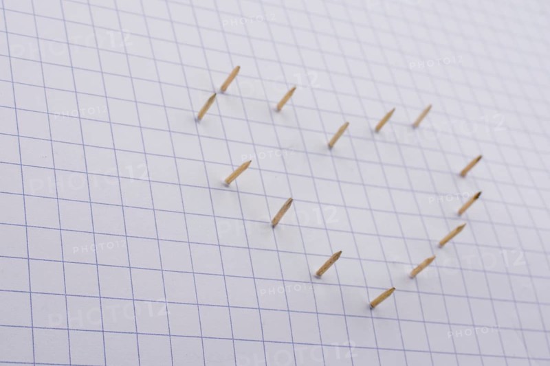 Nails make hole on paper forming a heart shape