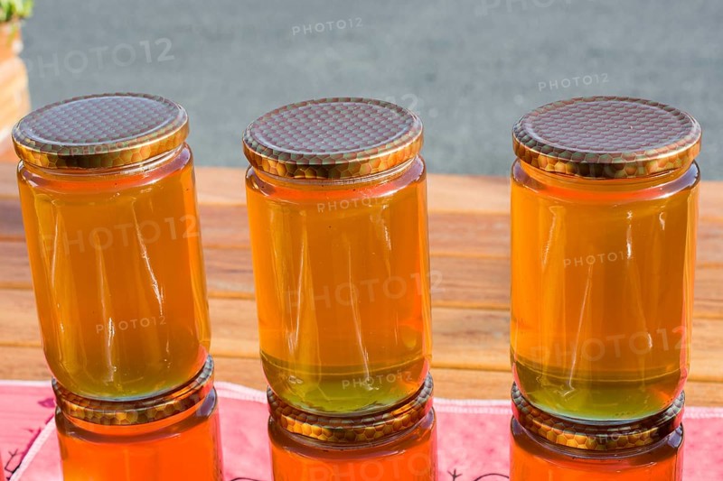 Glass jar of full of fresh honey with lid