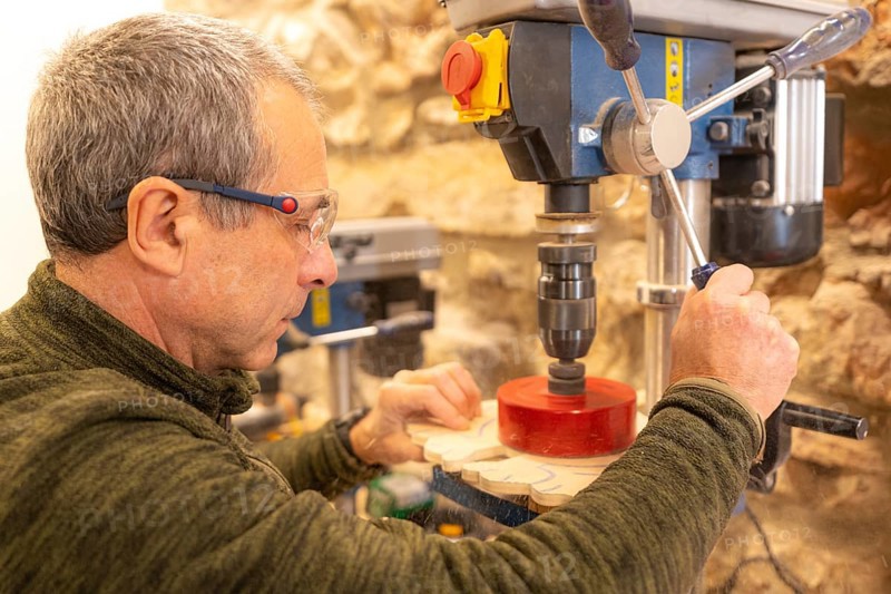 Close-up of a carpenter polishing a piece of wood in studio workshop