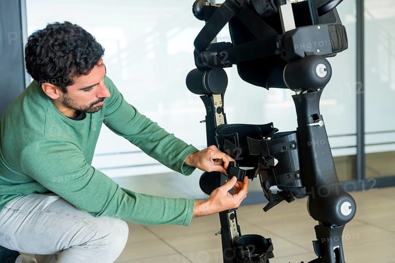 Mechanical exoskeleton engineer checking the mechanisms before the arrival of patients. Physiotherapy in a modern hospital: Robotic skeleton. Physiotherapy Rehabilitation Scientists