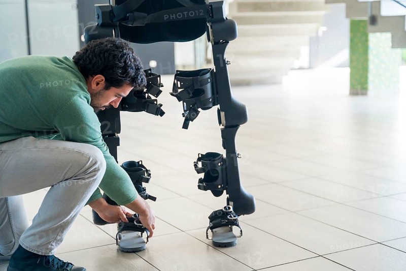Mechanical exoskeleton engineer checking robot before delivery to customer. Physiotherapy in a modern hospital: Robotic skeleton. Physiotherapy Rehabilitation Scientists