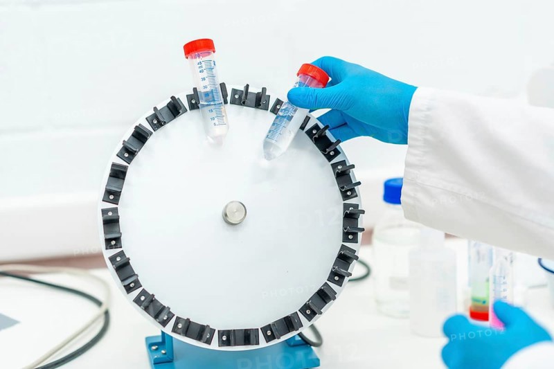 Top view of a scientist placing samples in centrifuge machine