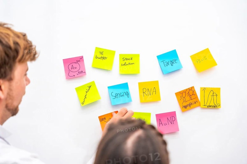 Rear view of a group of biologists in a creative brainstorming process with notes