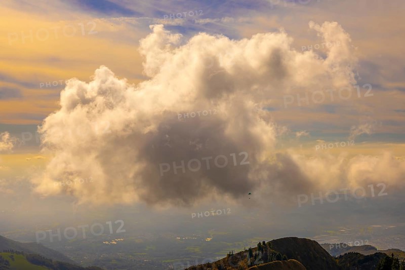 Aerial View over Beautiful Mountainscape with Floating Clouds and a Paraglider Flying with Sunlight From Monte Generoso