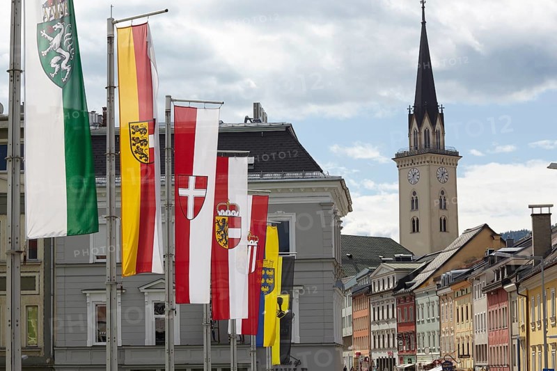 Flags on the Drau bridge with parish church