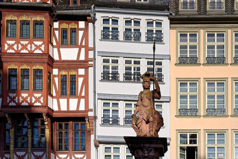 Fountain representing roman goddess Minerva in front of colorful Half-timbered houses in Roemerberg square