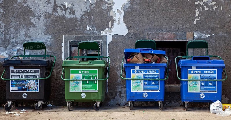 Dustbin in front of an old house wall