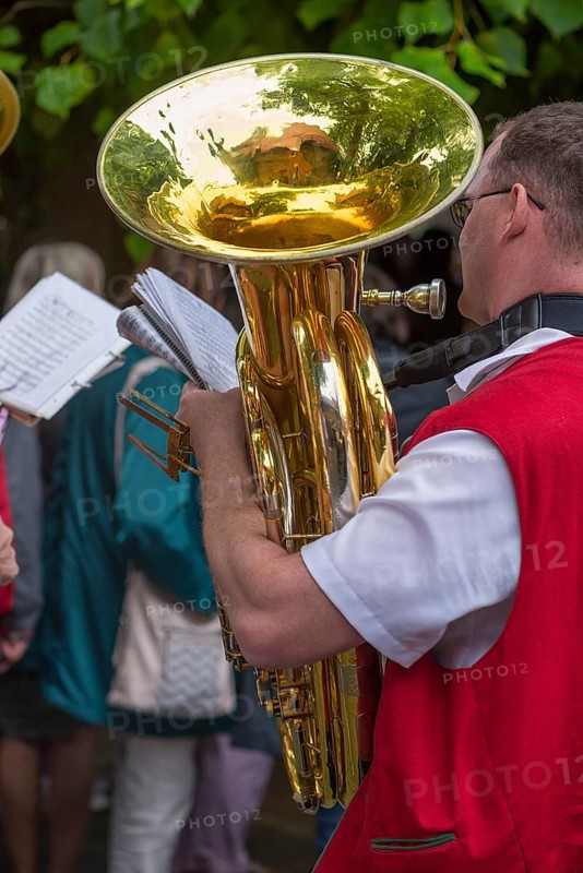 Musician holds his tuba and sheet of music ready to play