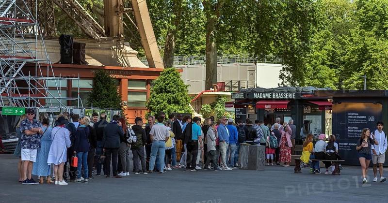 Queue in front of a brasserie below the Eiffel Tower
