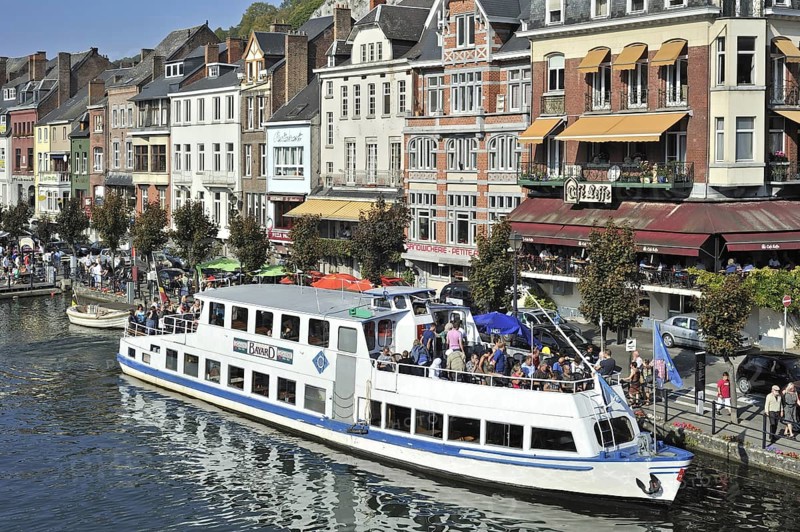 Tourists on sightseeing trip by pleasure boat on the river Meuse at Dinant