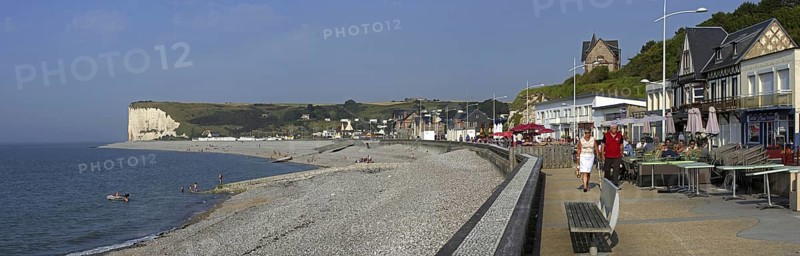 Pebble beach and tourists at pavement cafe on promenade at Veulettes-sur-Mer