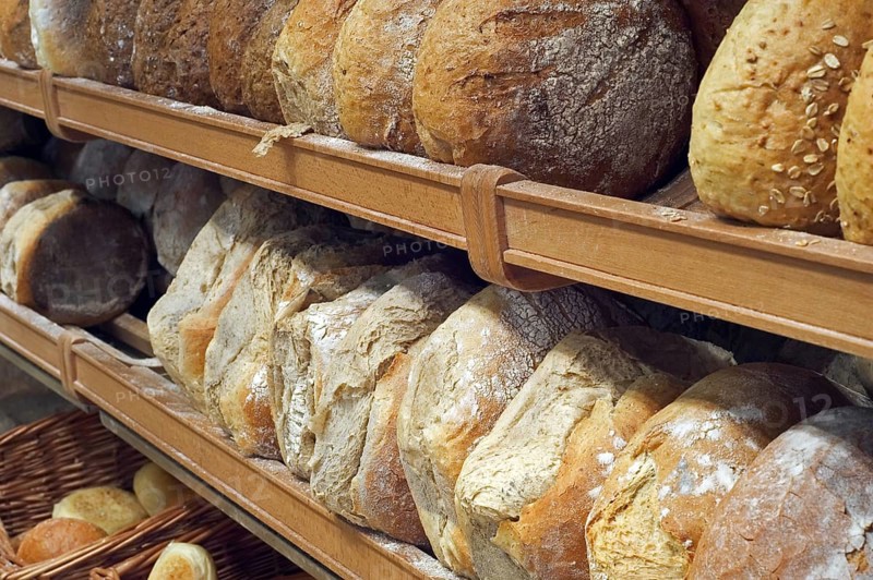 Shelves with loaves of fresh baked bread on display in bakery