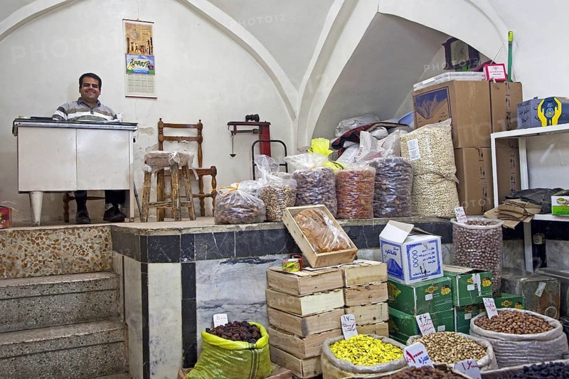 Seller selling spices in shop in the old historic bazaar of the city Tabriz