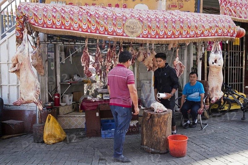 Uyghur street butcher selling pork's meat at butcher's shop