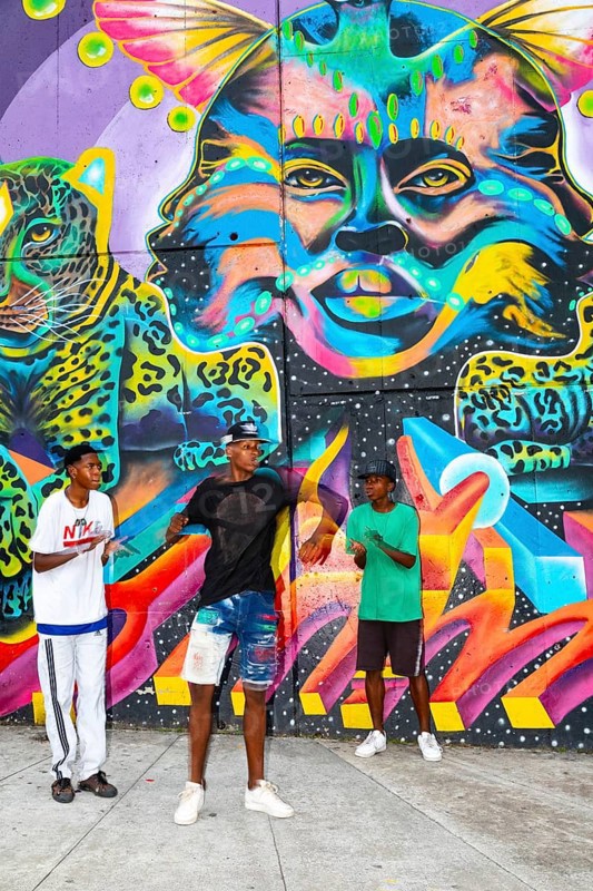 Breakdancing in front of graffiti on the wall of a house