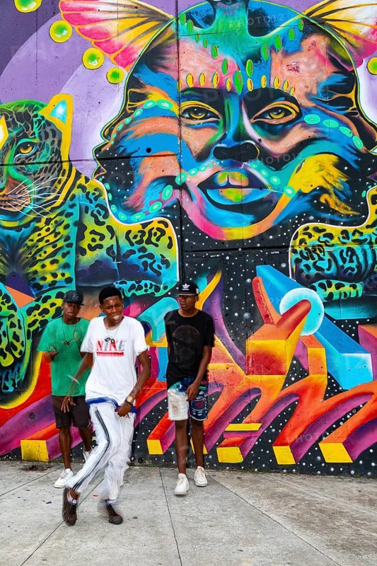 Breakdancing in front of graffiti on the wall of a house