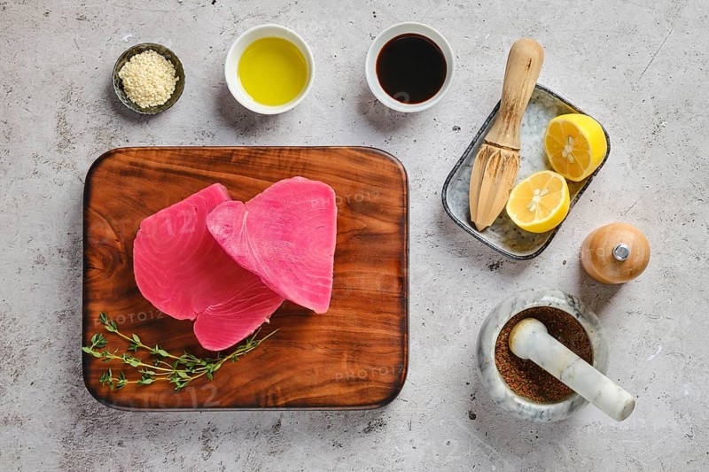 Top view of raw ahi tuna steak on cutting board with spice