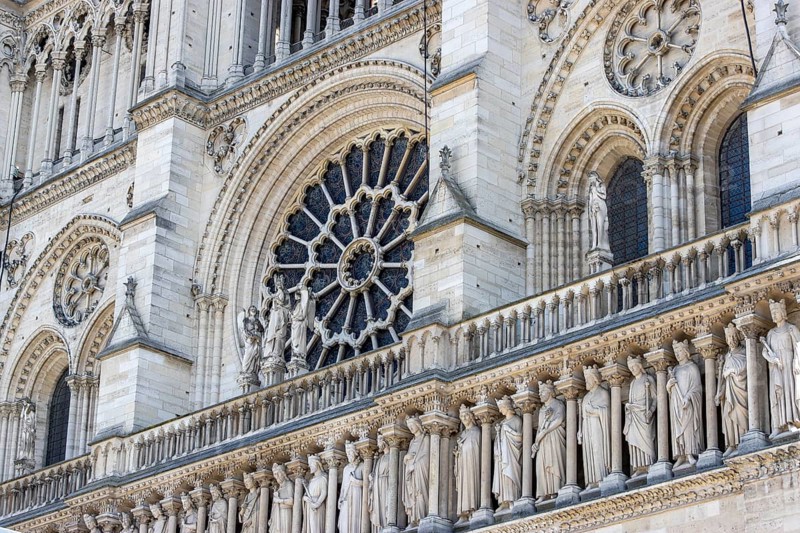 Detail of Notre Dame de Paris Cathedral with rose window or rose window and sculptures below