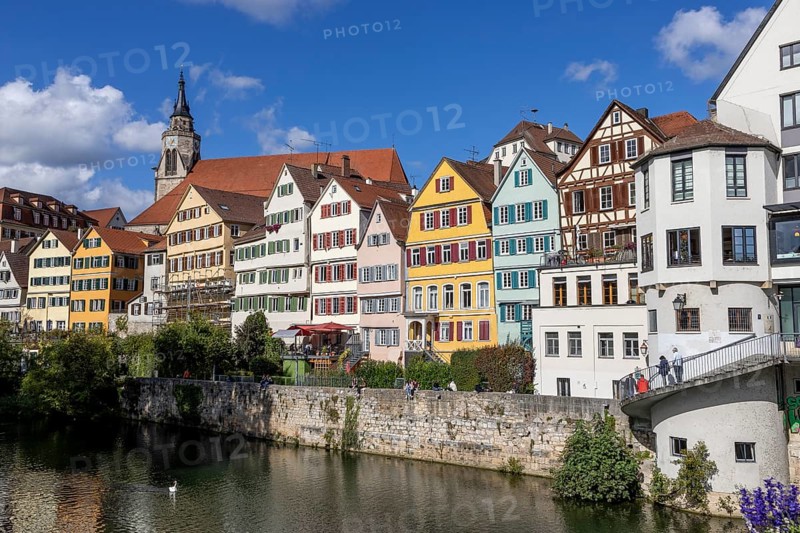 Colourful houses in the old town on the banks of the Neckar with the church tower of St. George's Collegiate Church