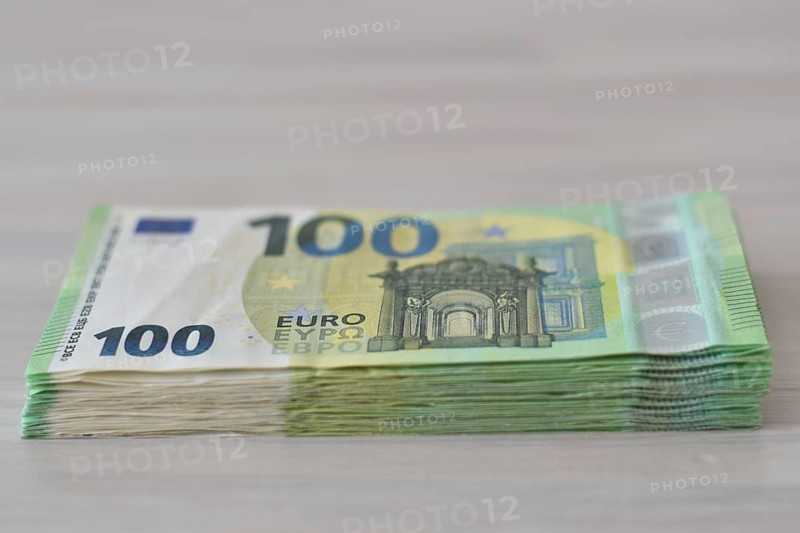Many one hundred euro notes in a pile on a table