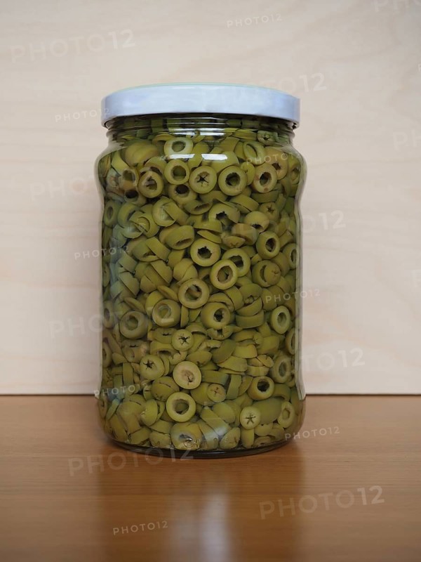 Sliced green olives in brine in glass jar