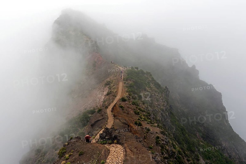 Hikers on the PR1 Vereda do Areeiro hiking trail in the fog