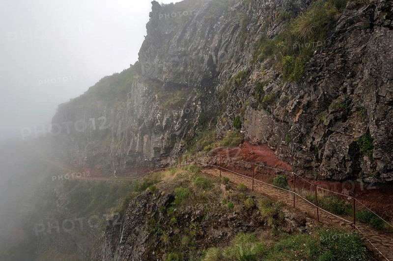 Hikers on the PR1 Vereda do Areeiro hiking trail in the fog