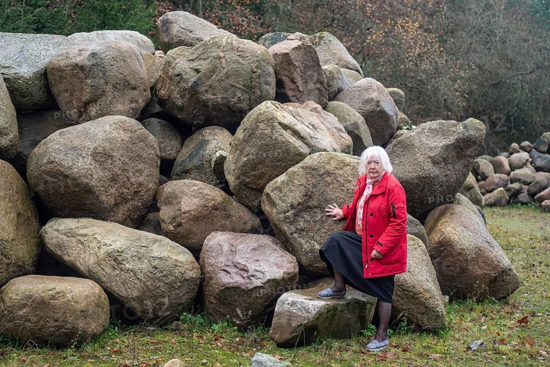 Woman stand at a stone storage in the nature in Fyledalen