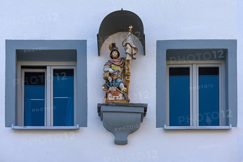 Figure of St Florian under a canopy on a house
