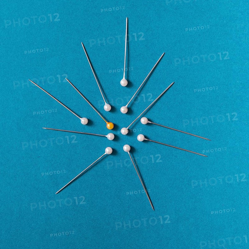 Overhead view yellow push pins with white pins blue background