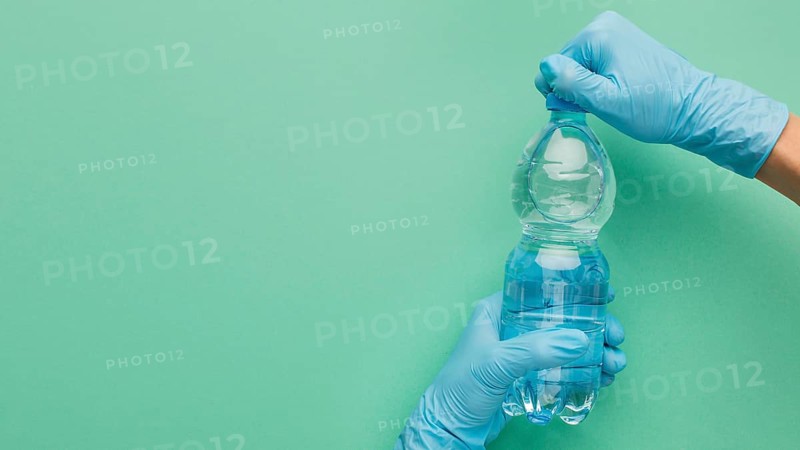 Person wearing gloves opening bottle