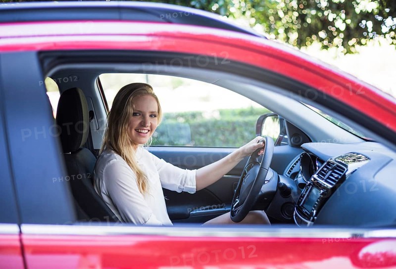 Portrait happy woman sitting inside car